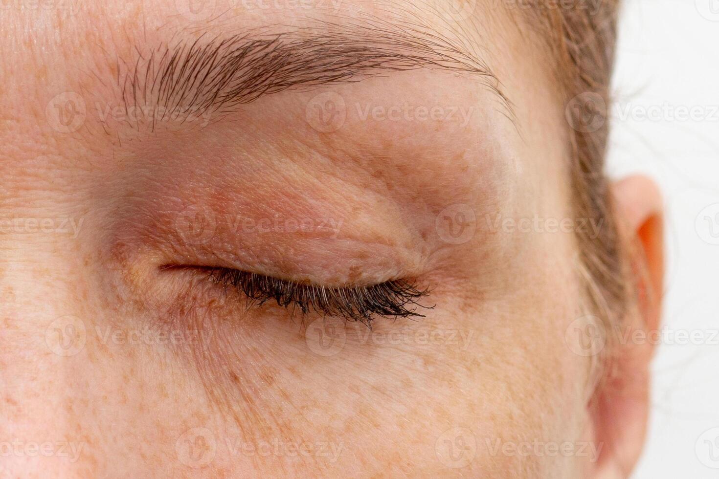 Close up cropped closed eye of middle aged caucasian woman looking at camera photo