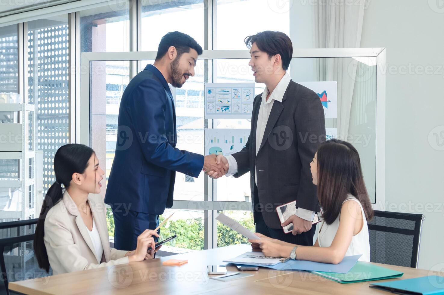 Portrait business team woman and man asian group stand on wall white looking and shake hand with in agreement cooperate successful new project ready for happy working online sale inside home office photo