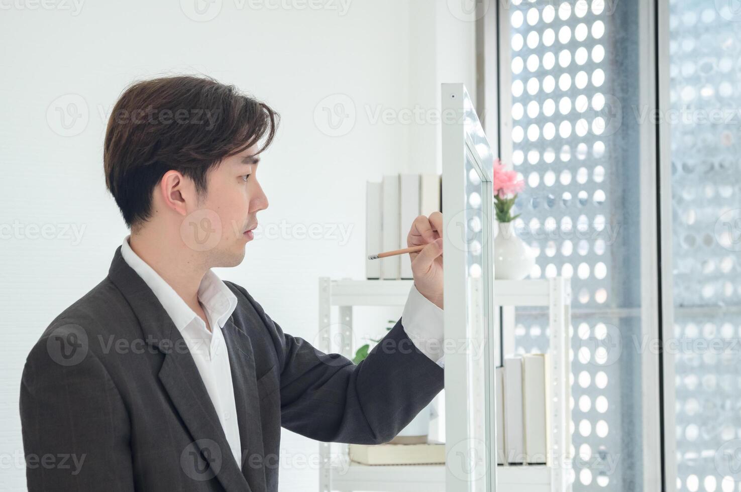 Portrait business man one oerson handsome smart Asian stand holding pen and looking creative write note plan maketing idea project ready for happy working online sale inside home office with intention photo