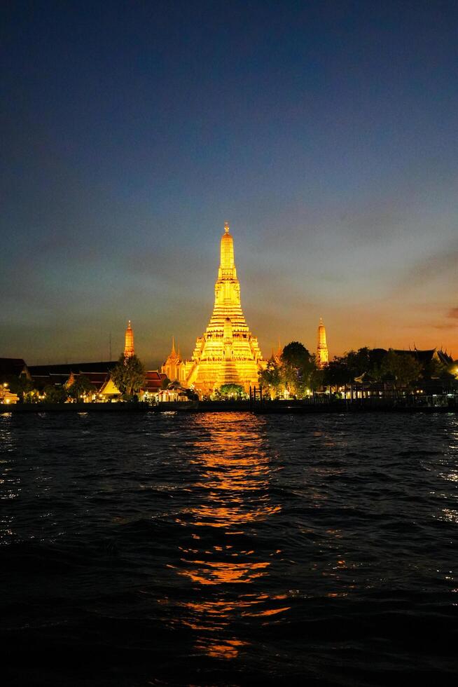 Bangkok, Thailand, 2024 - Wat Arun Temple or The Temple of Dawn in the evening in front of Chaopraya River, Bangkok photo