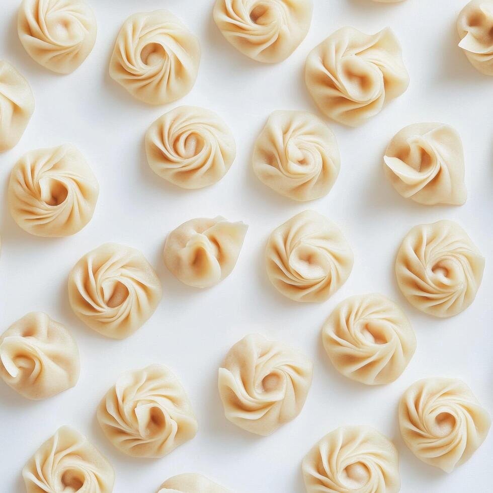 Dumplings arranged neatly on a white surface for culinary display and preparation in a kitchen setting photo