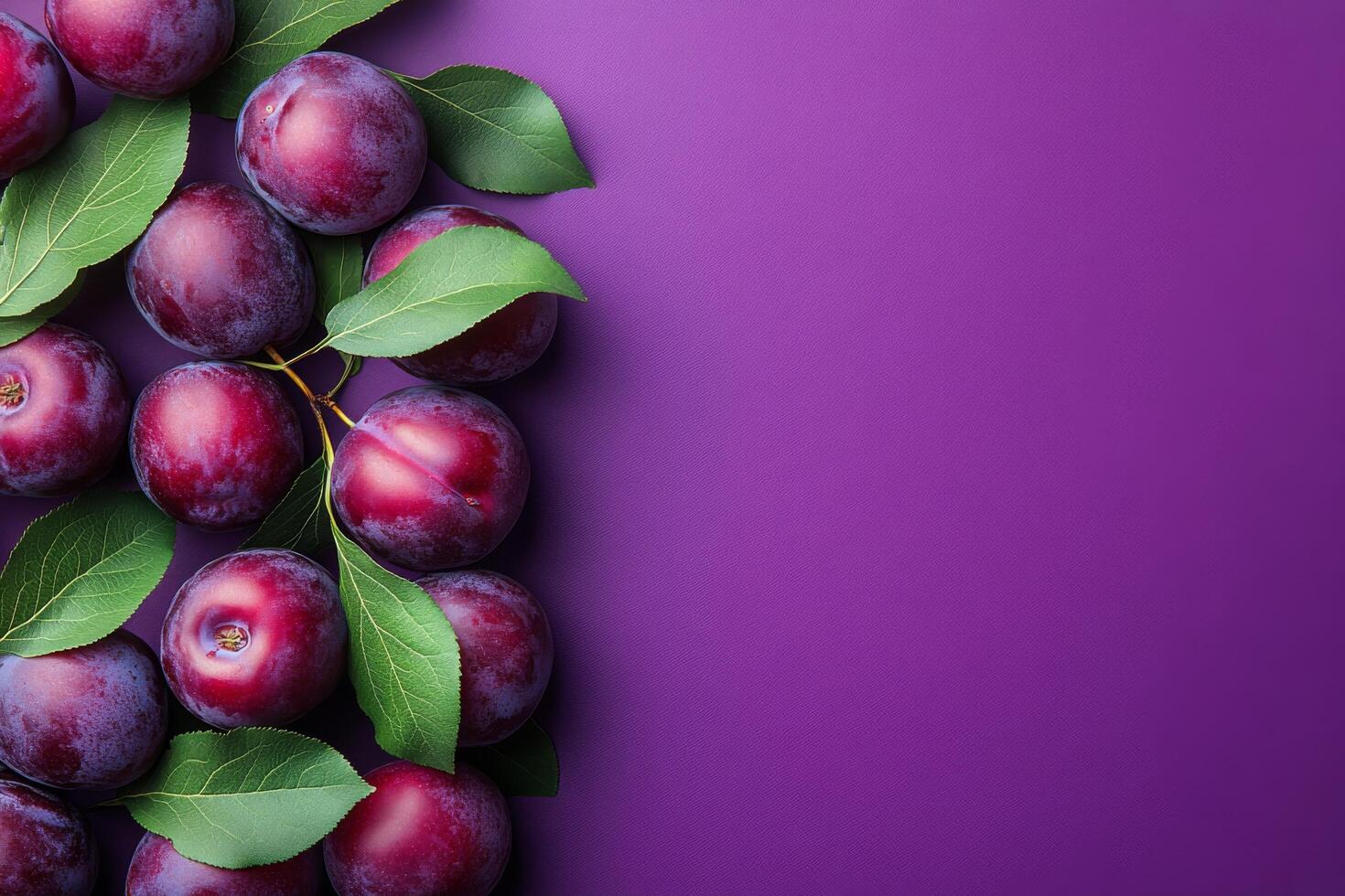 Fresh plums with leaves arranged on a vibrant purple surface photo