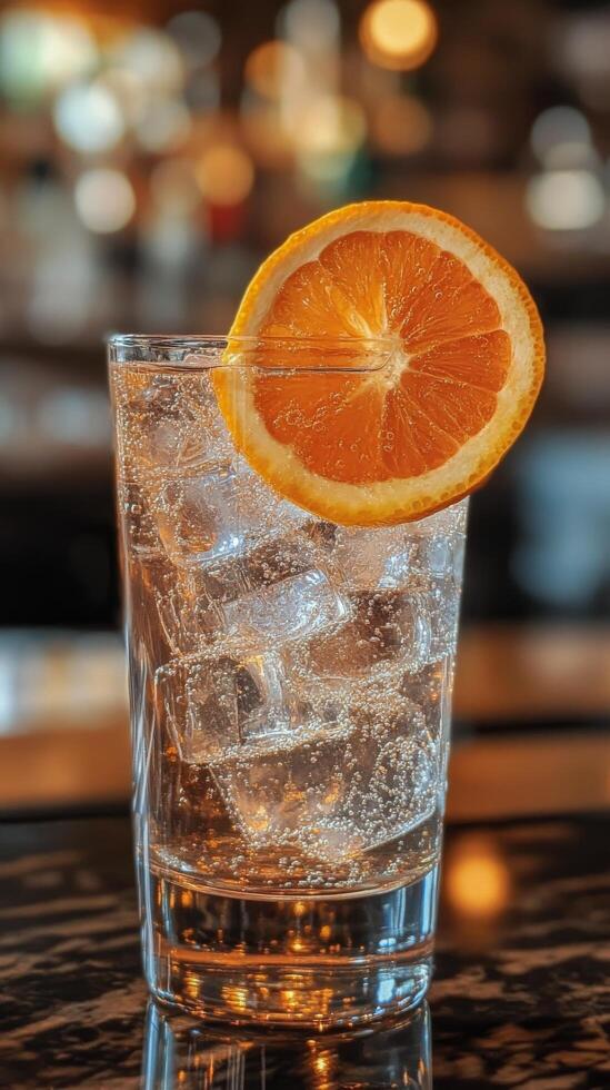 Refreshing drink garnished with orange slice on a sunny table surrounded by fresh oranges photo