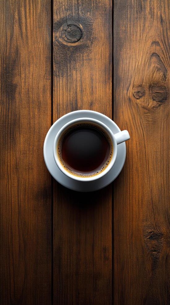 Rich black coffee served in a white cup on a rustic wooden table in a cozy setting photo