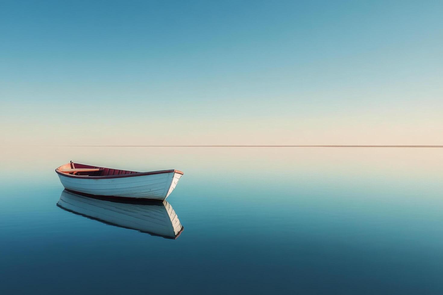 Calm waters reflect a lone boat at sunrise in a tranquil setting by the shore photo