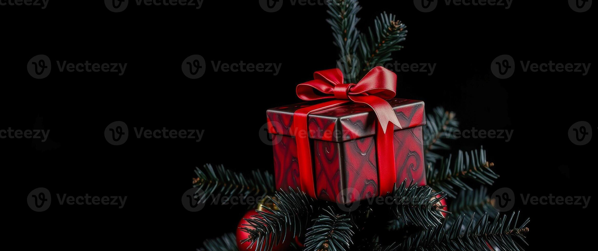 red gift box with ribbon on artificial tree branch photo