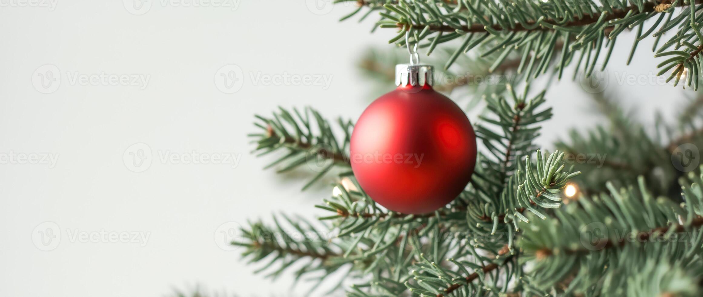 red glass ball hanging on a green branch photo