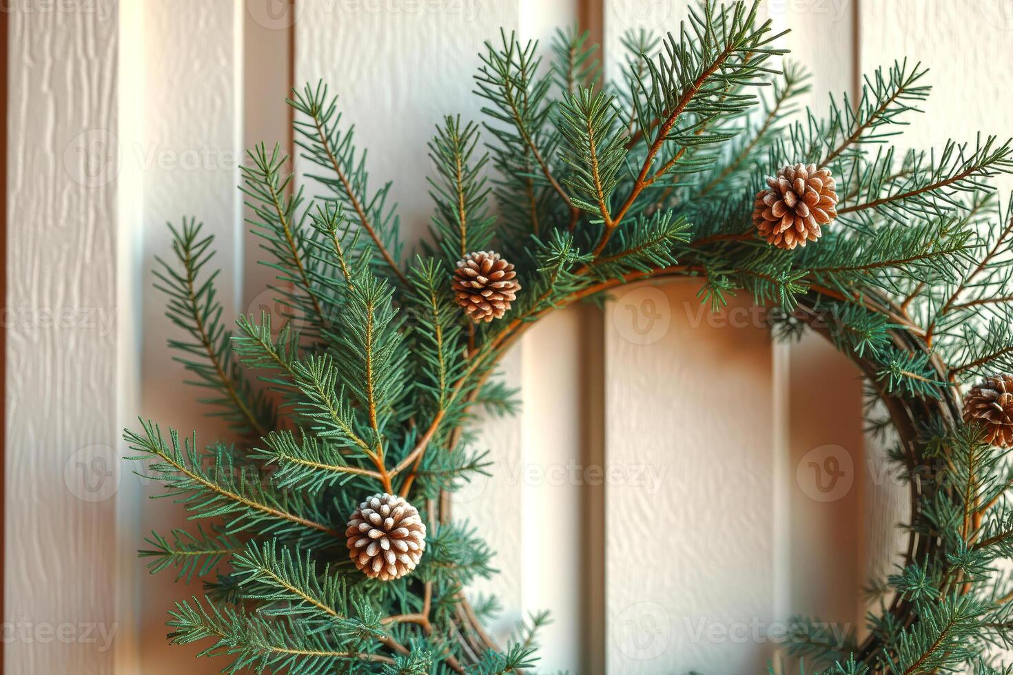 handcrafted evergreen wreath with light brown pinecones hangs on a textured wall. photo