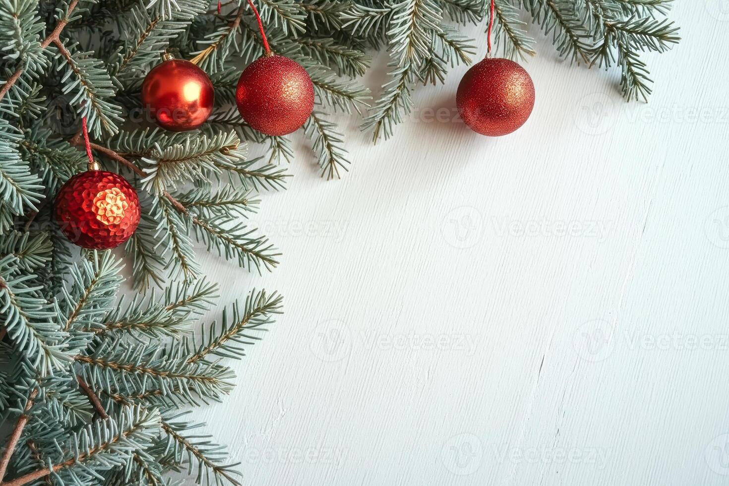 red spherical ornaments adorn evergreen branches against a white backdrop photo