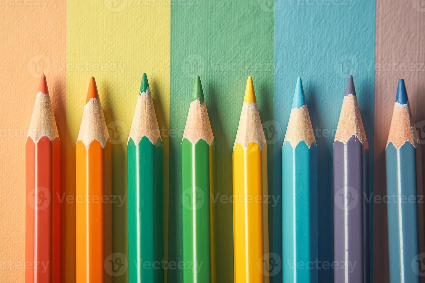 eight sharpened colored pencils arranged against a multicolored background photo