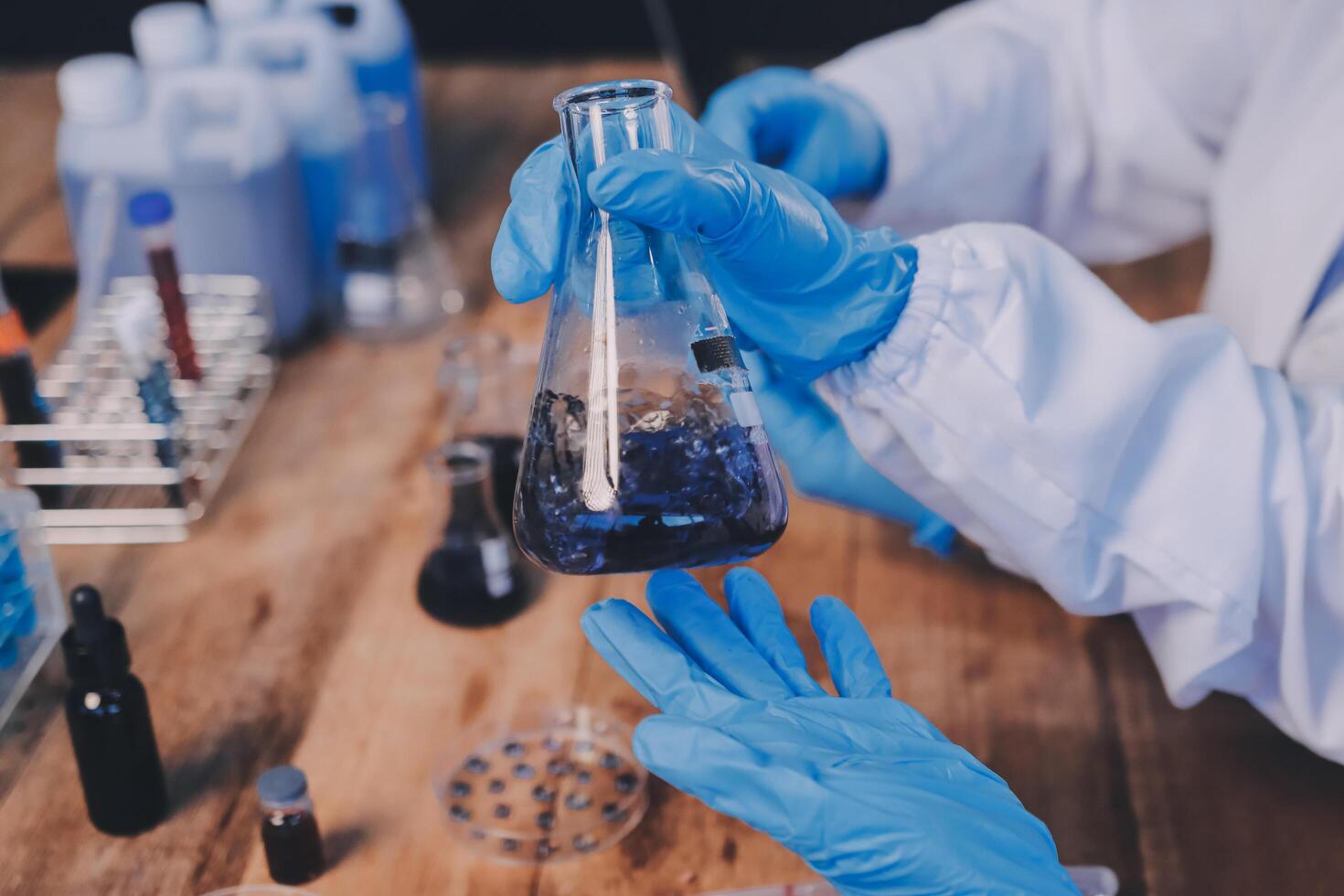 Blood test in the laboratory. Laboratory assistant working with the dispenser. Vacuum tubes with blood. photo
