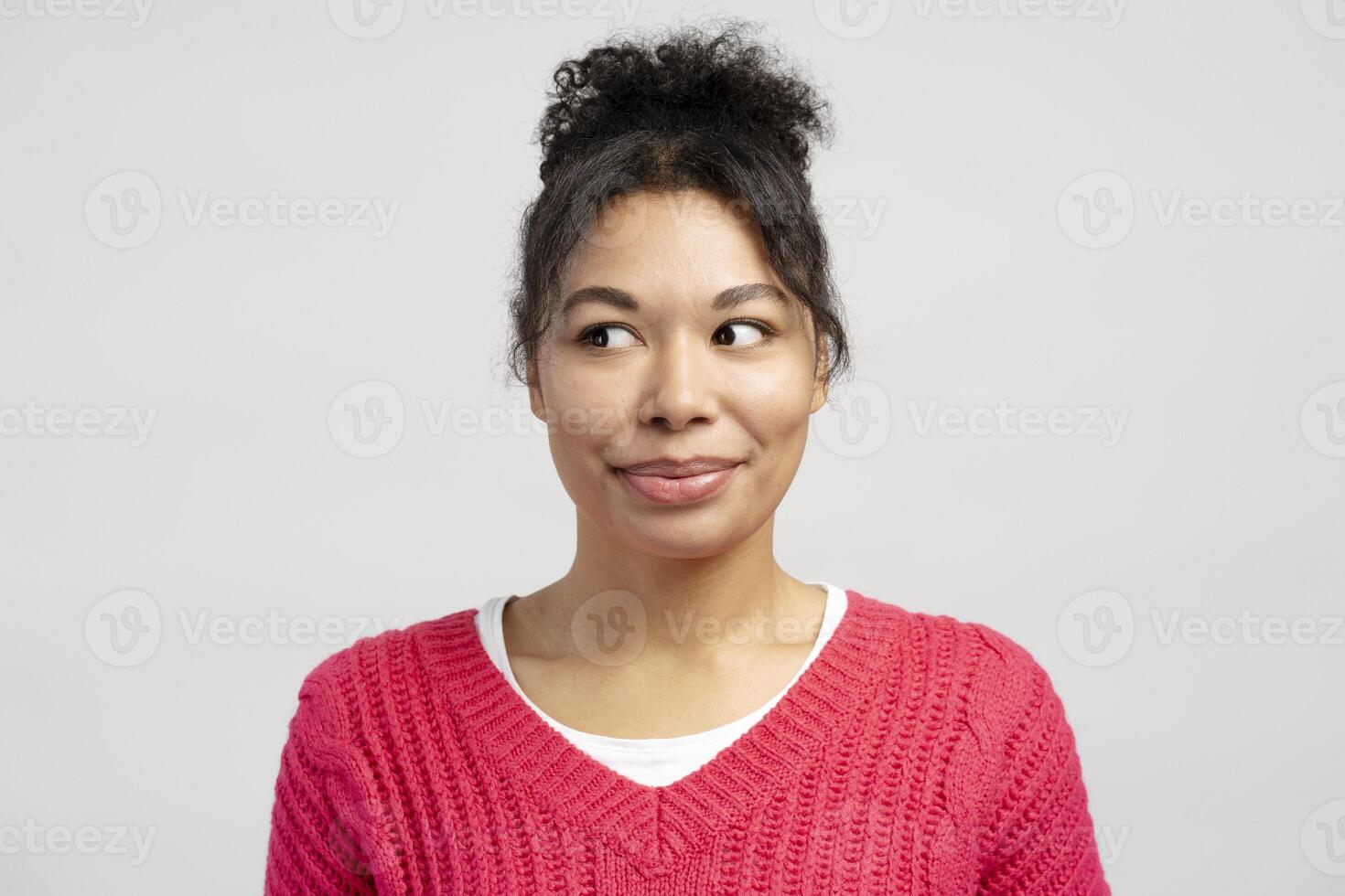 Curious young woman looking sideways on white background photo