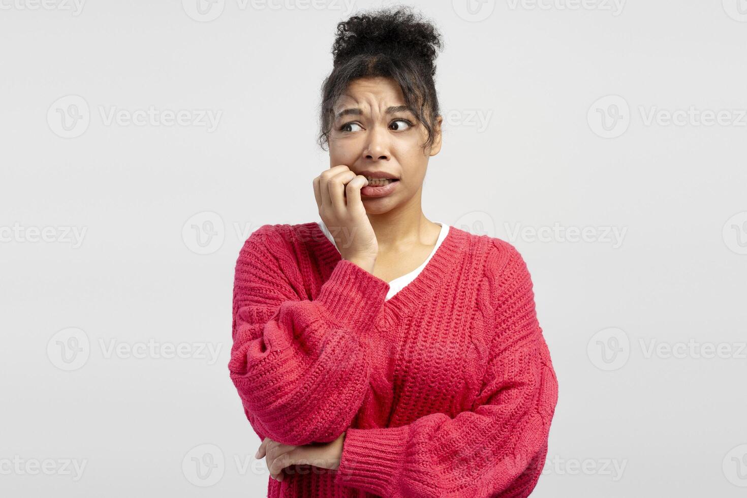 Worried young woman biting her nails on white background photo