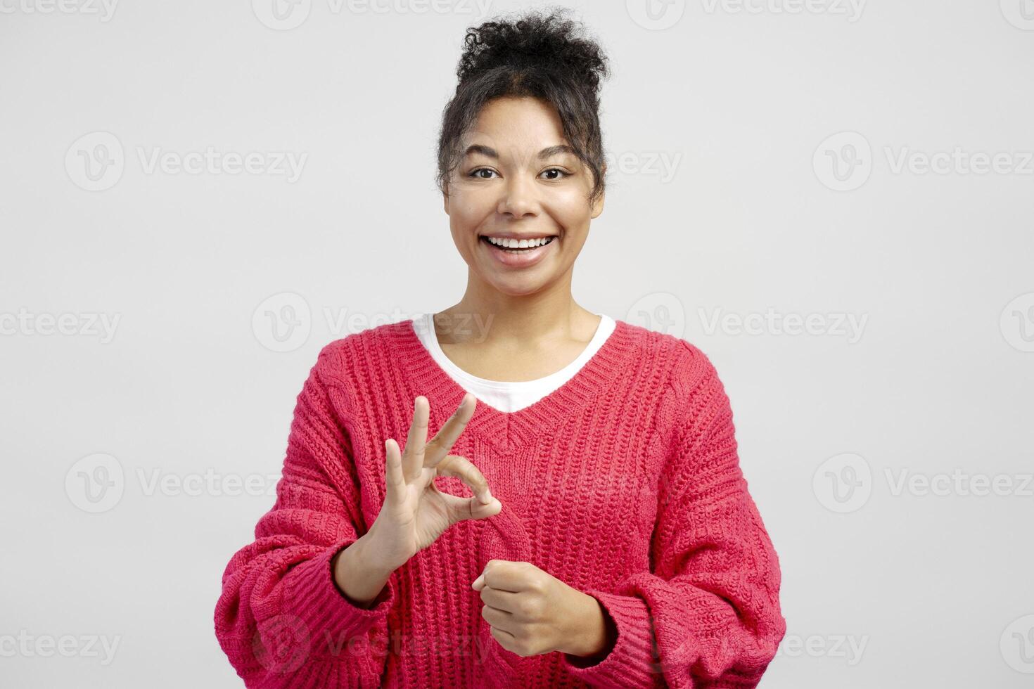 Cheerful woman showing ok sign with fingers, approving and agreeing, on white background photo