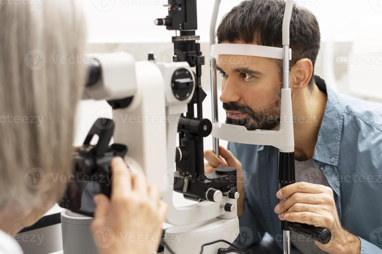 Ophthalmologist taking photos of patient's eye with slit lamp