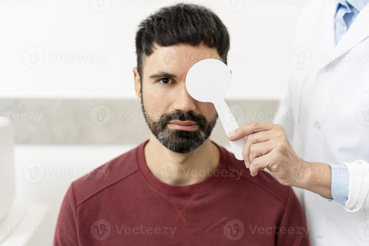 Doctor examining patient's vision with occluder in medical clinic photo