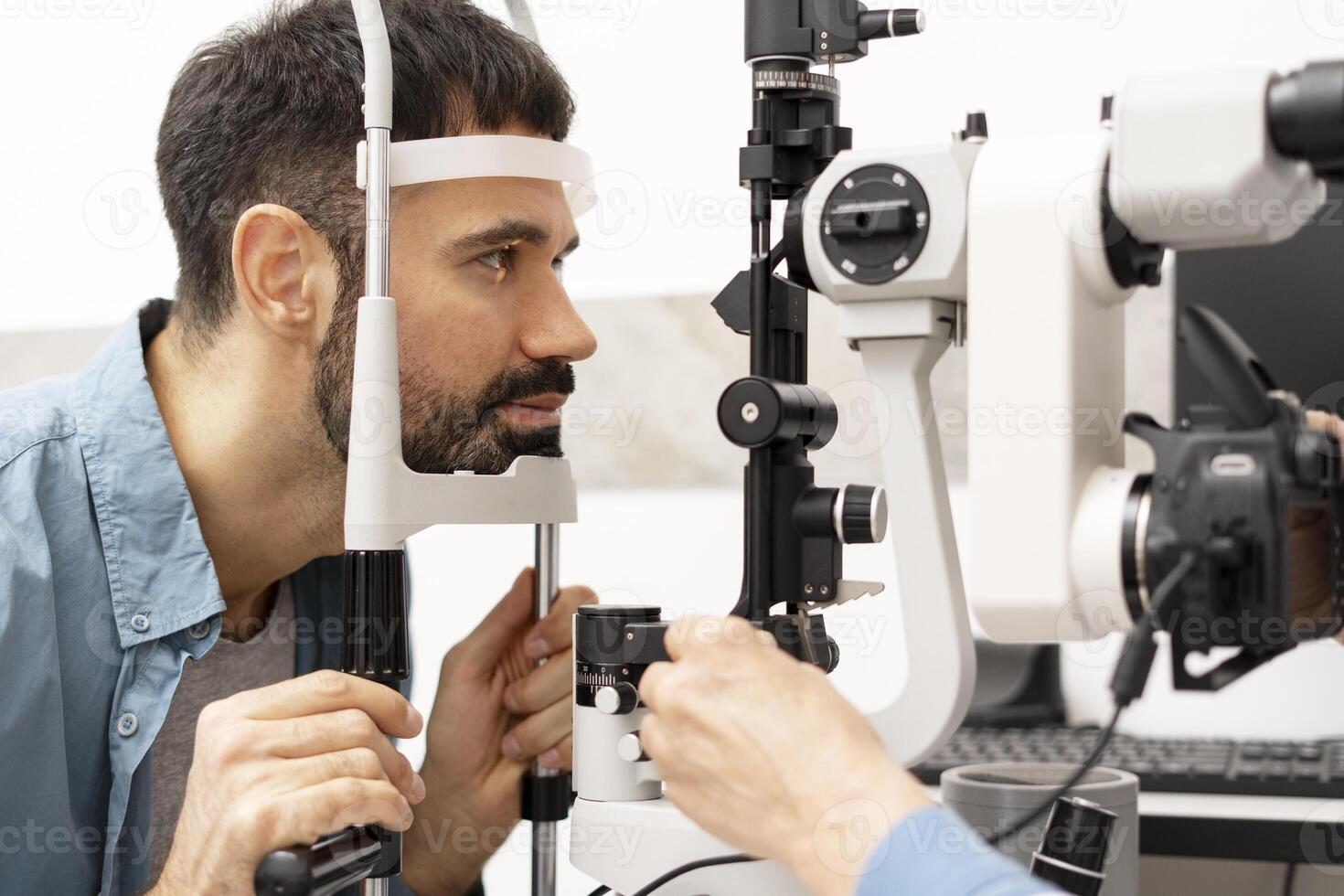 Optometrist examining patient's eyesight with slit lamp and camera in ophthalmology clinic photo