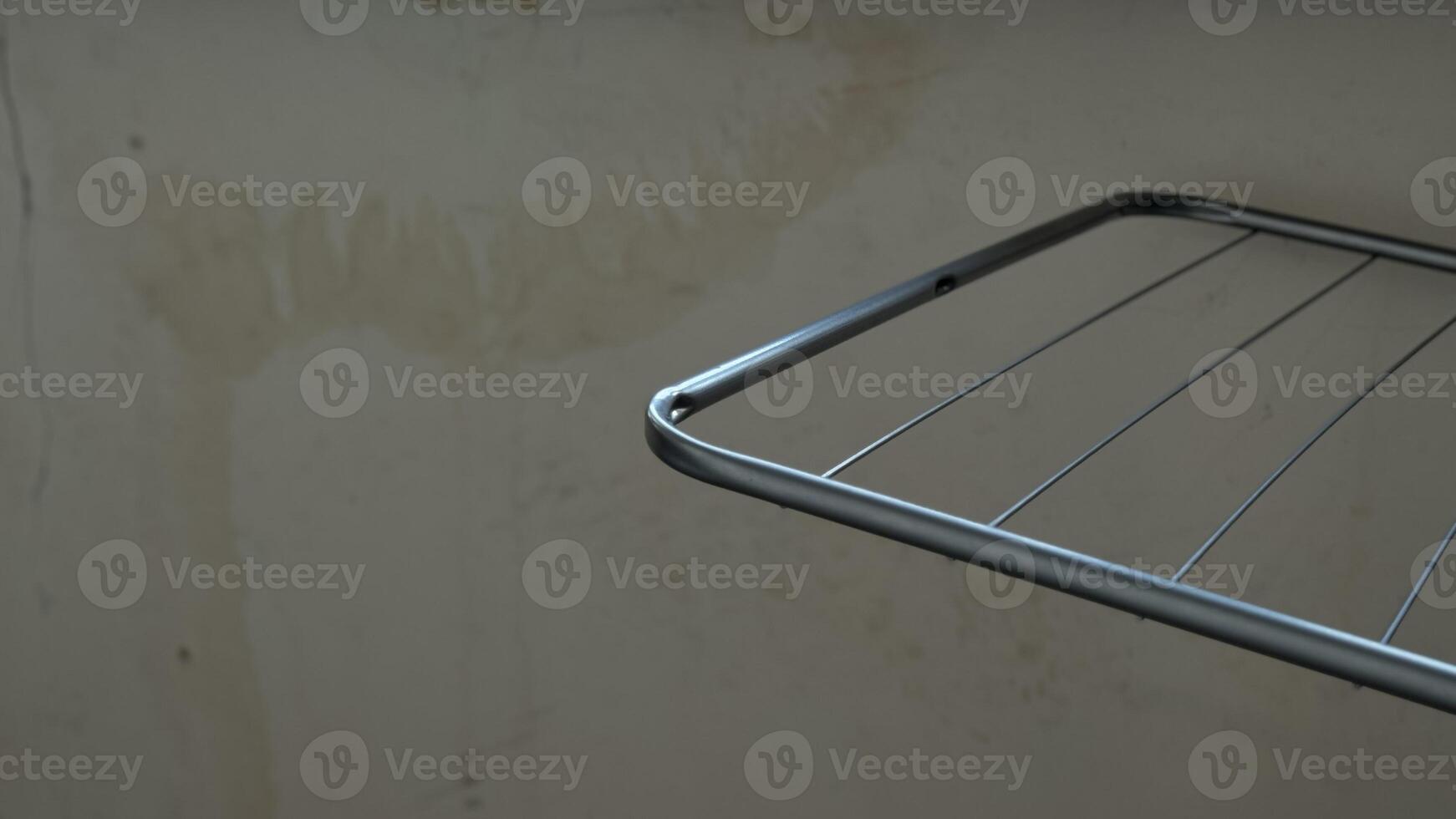 A Metal Drying Rack Positioned Elegantly Against a Bare Wall for Maximum Utility and Style photo