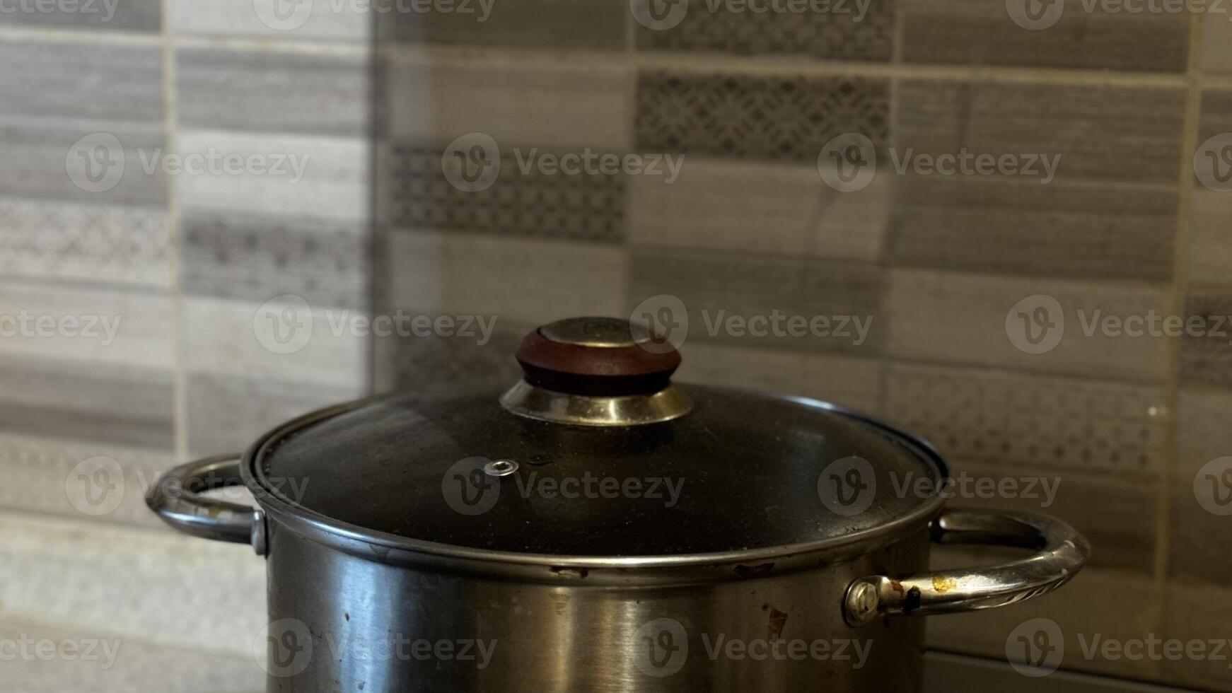 A beautiful cooking pot sits prominently on the kitchen counter adorned with modern, stylish tiles photo