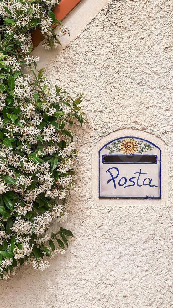 Vintage Post Box Decorated with Flowers on a Rustic Wall photo