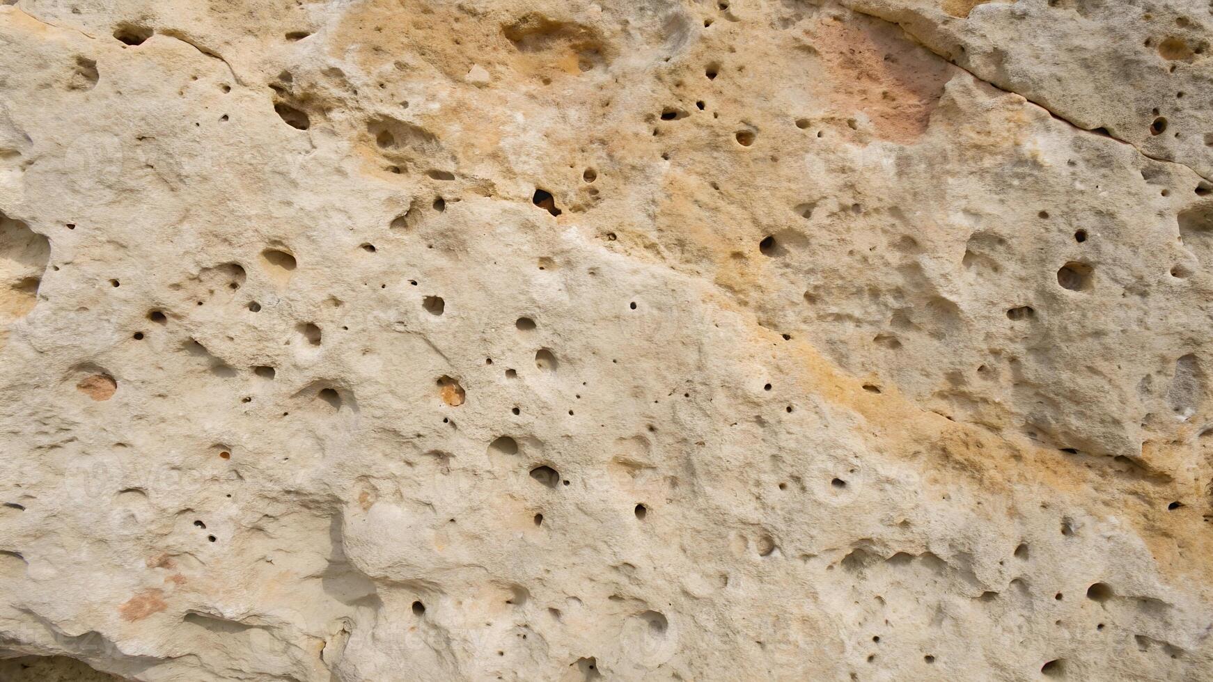 Porous Limestone Texture with Pockmarks and Subtle Color Variations photo