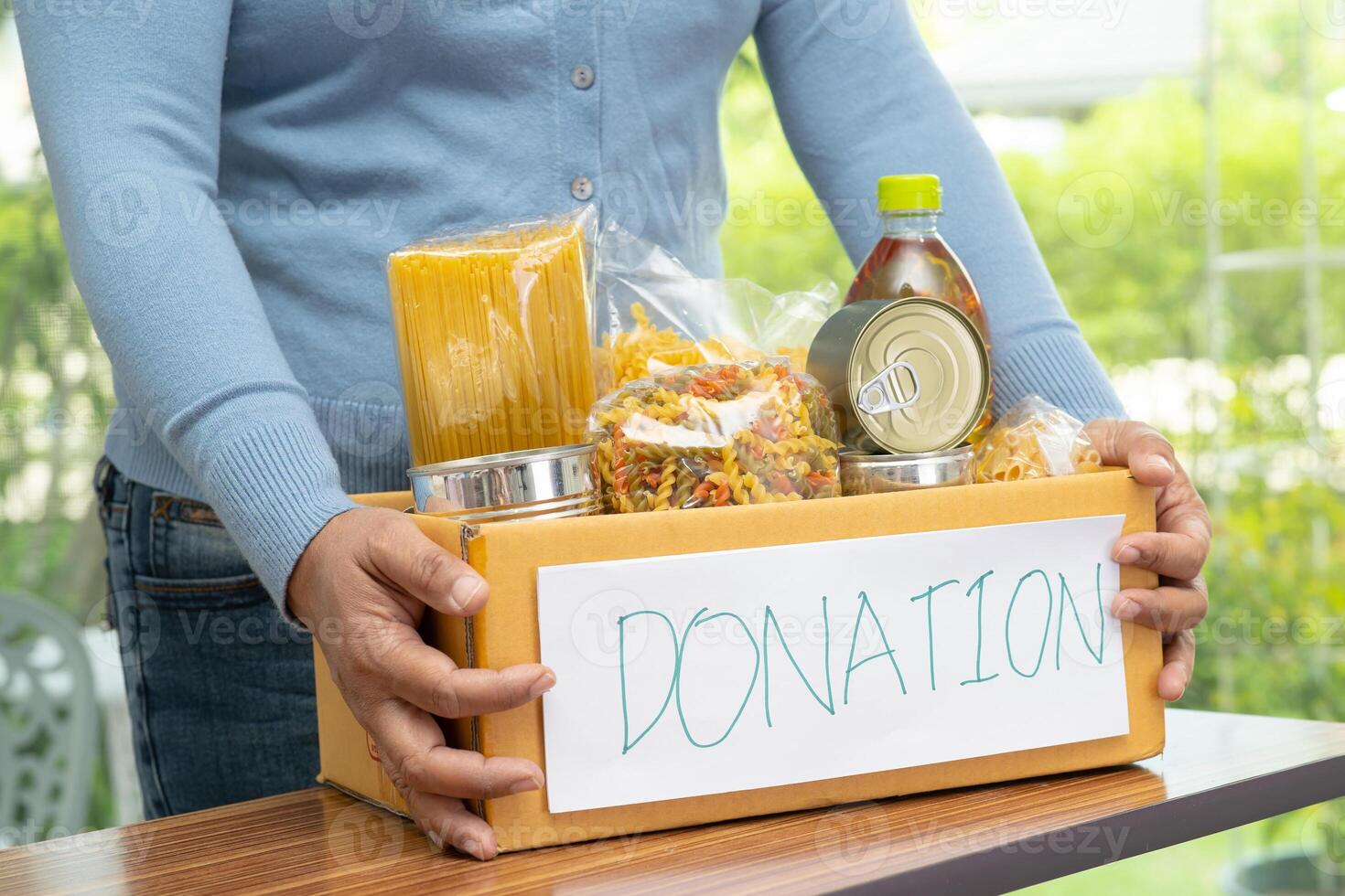 Volunteers putting various dry food in donation box for help people. photo