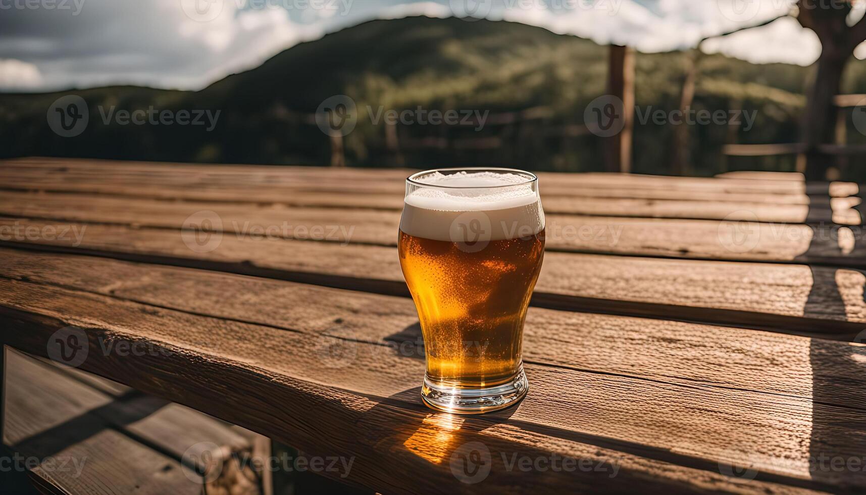 Glass of Beer on Wooden Table with Mountain View photo