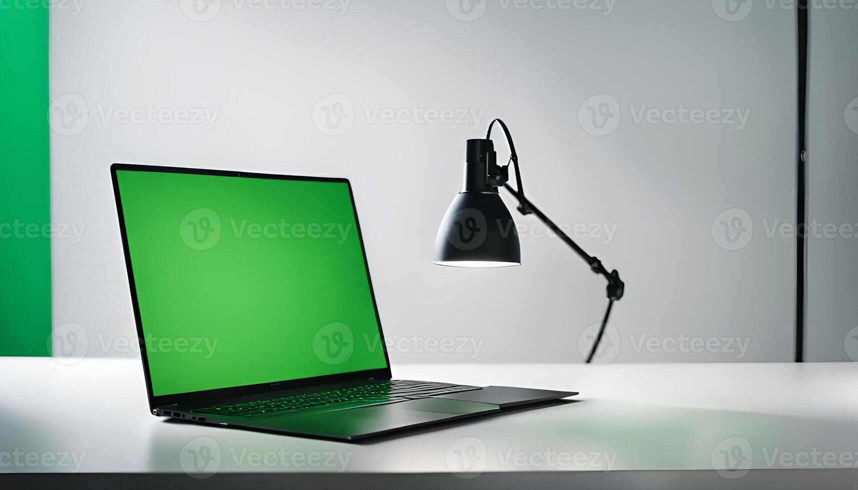 Laptop with Green Screen and Desk Lamp photo