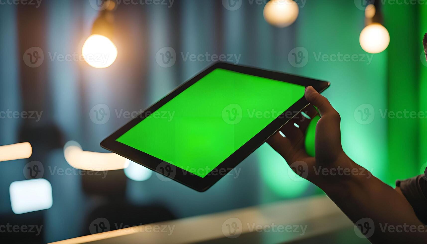 Closeup of a Hand Holding a Tablet With a Green Screen photo