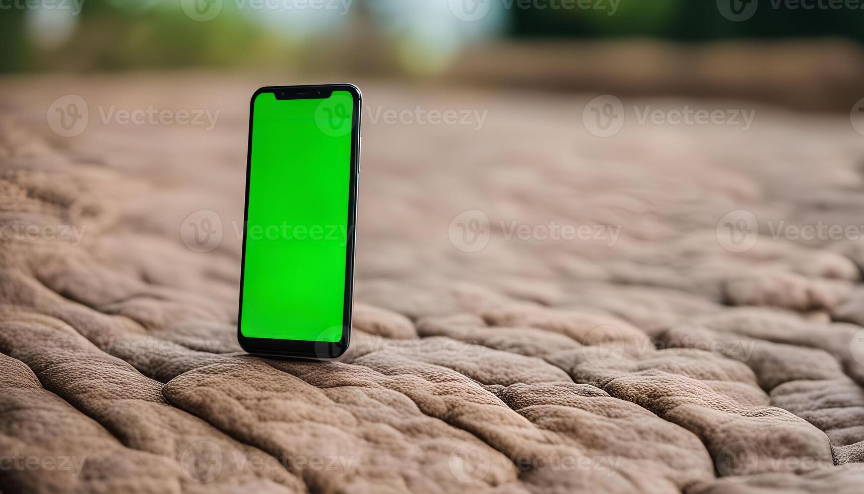 Smartphone with Green Screen on a Textured Surface photo