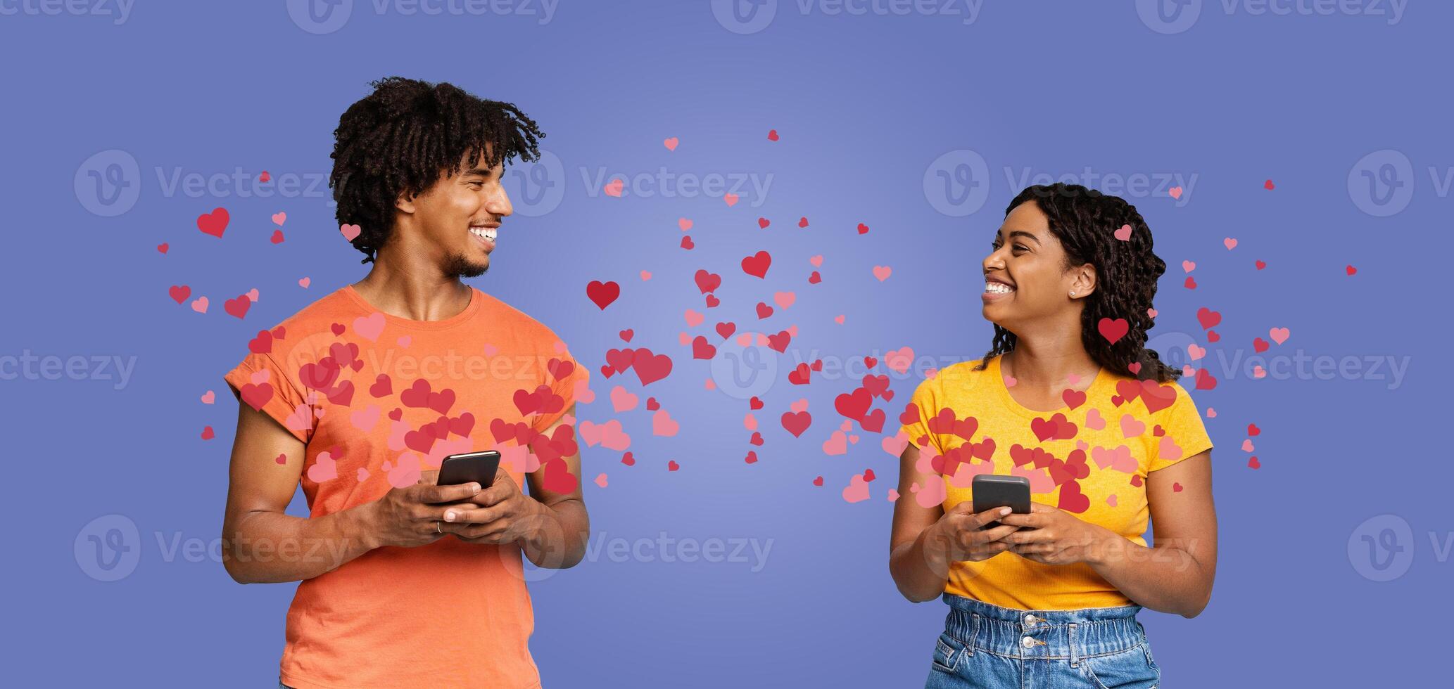 Indian couple enjoys a special moment, exchanging loving glances and smiles while using their phones. Surrounded by heart graphics, they celebrate their bond on Valentine's Day. photo