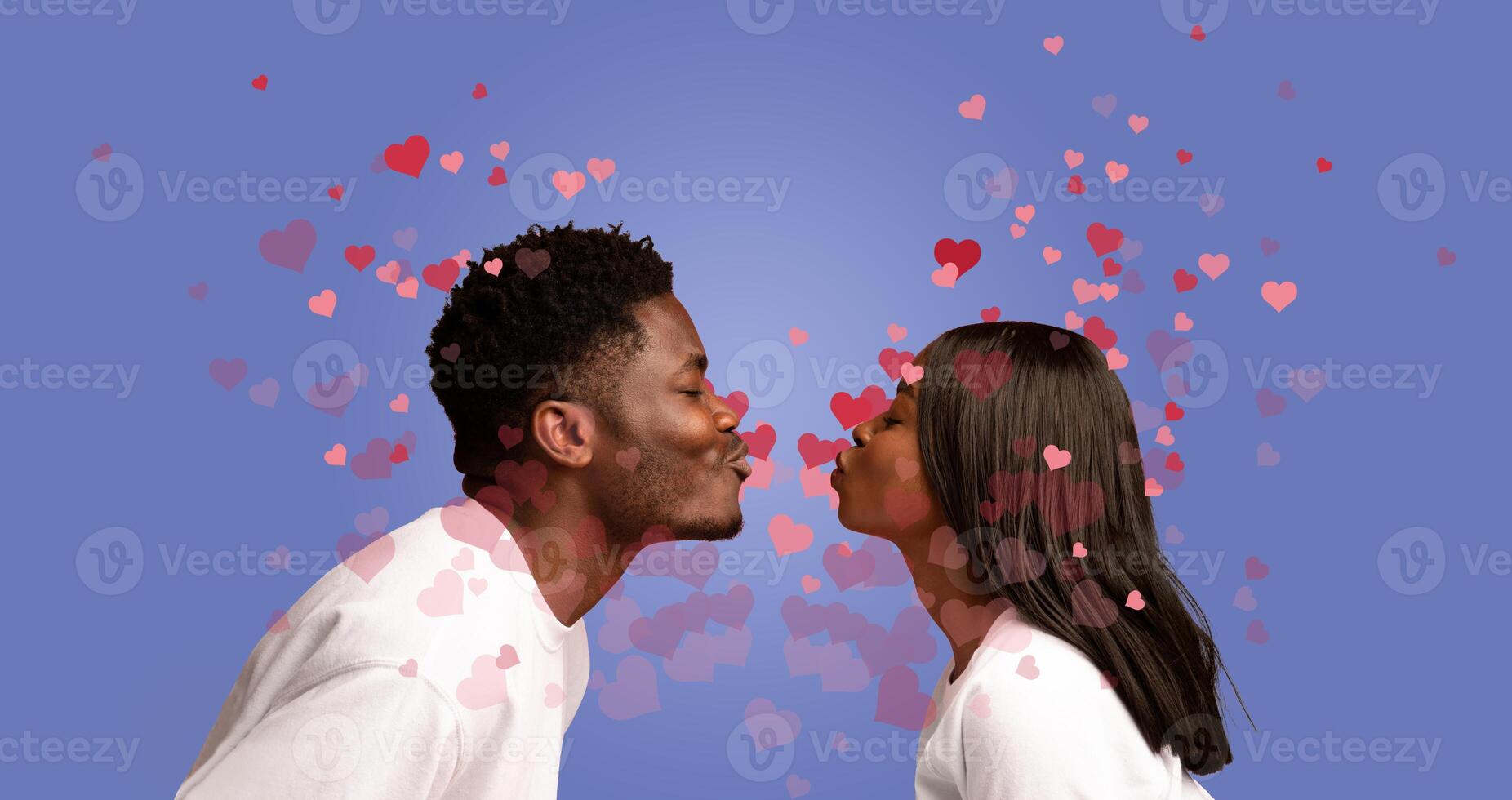 A black couple celebrates their love with a tender kiss, surrounded by floating hearts. This romantic moment captures the essence of affection and bonding on a special day together. photo