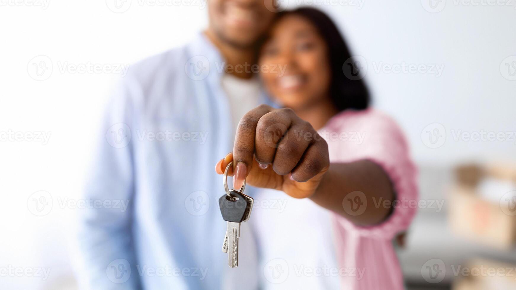 Family housing concept. Happy african american spouses holding new house key, selective focus, shallow depth. Real estate, property ownership and mortgage photo