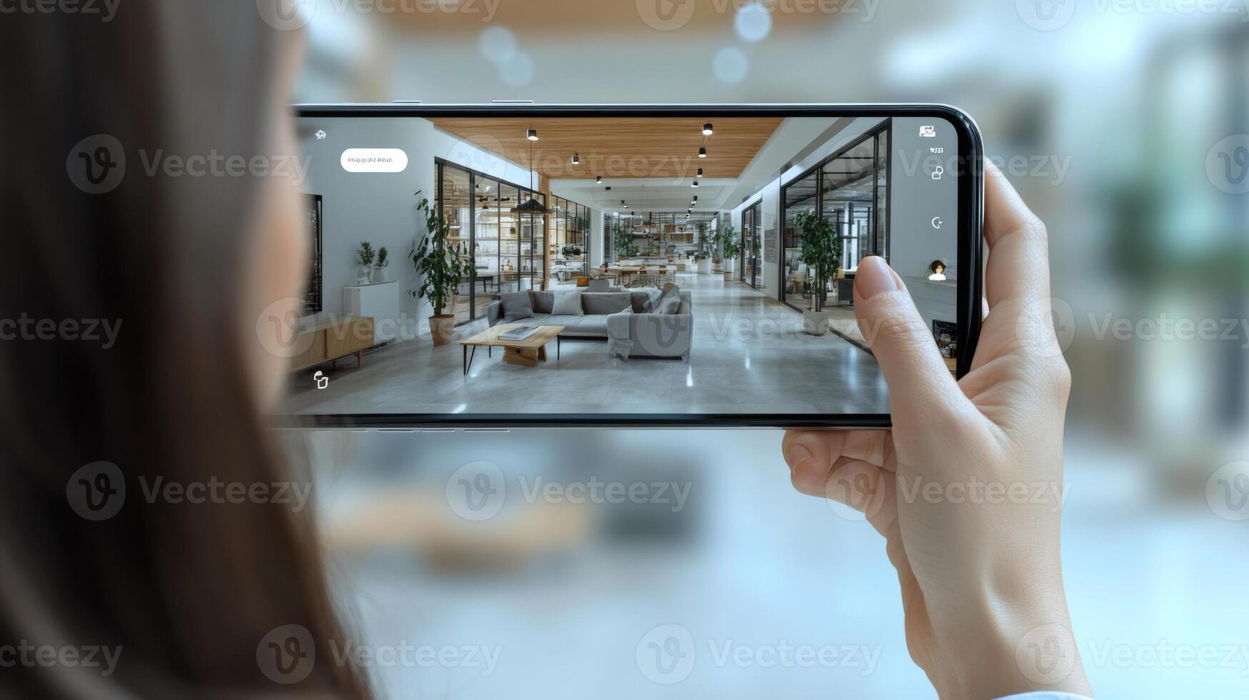 A person is taking pictures in a bright interior design showroom. The space is filled with contemporary furniture and plants, showcasing an open layout and a stylish atmosphere. photo
