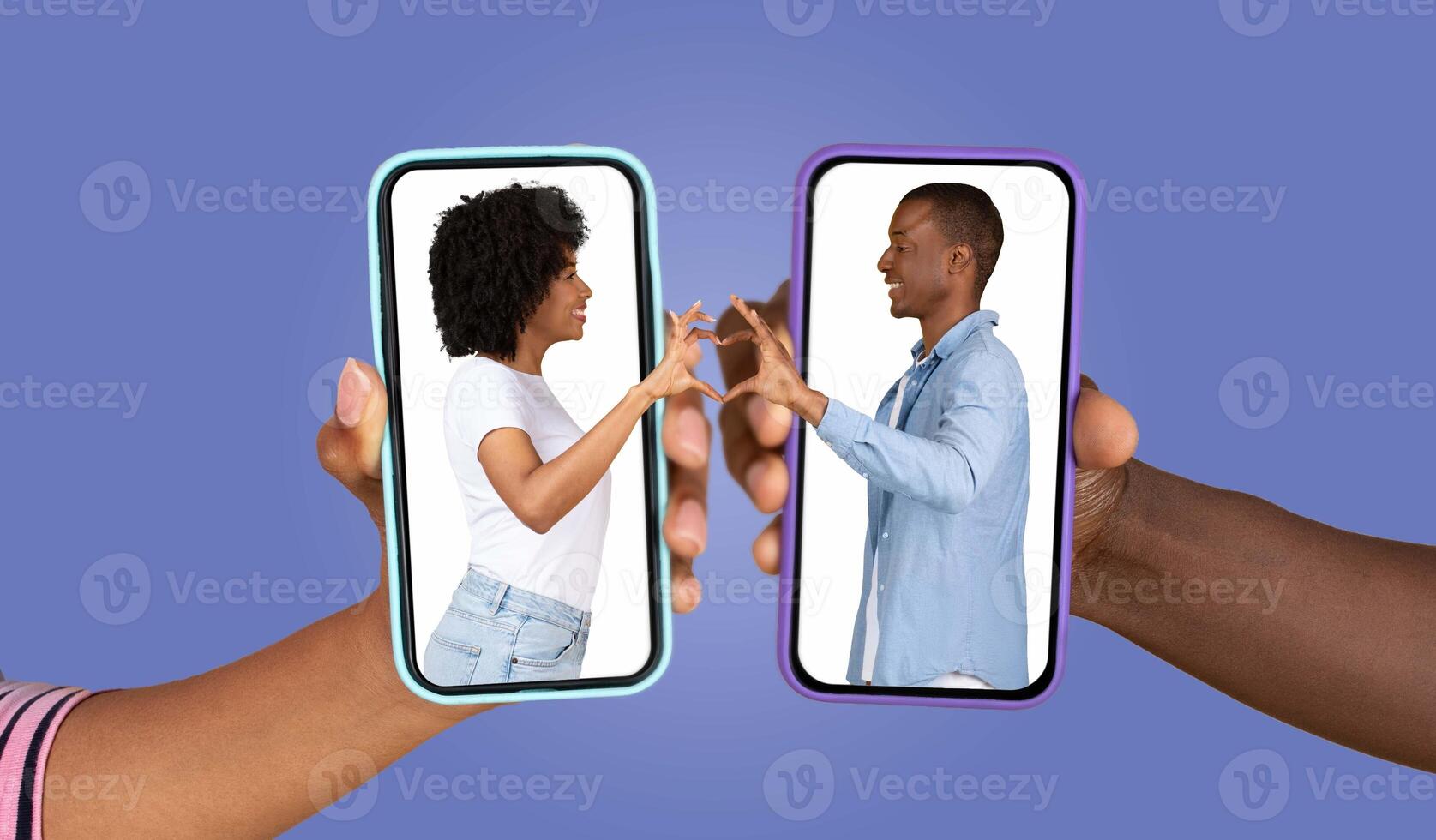 Two hands hold smartphones displaying a couple expressing affection through a virtual heart gesture. The vibrant background emphasizes their loving interaction, bridging distance with technology. photo
