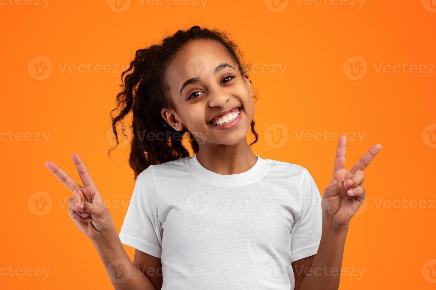 Peace Concept. Portrait of positive cheerful black teenage girl posing and showing 2 fingers doing victory v sign gesture, looking at camera. Number two, success and triumph photo