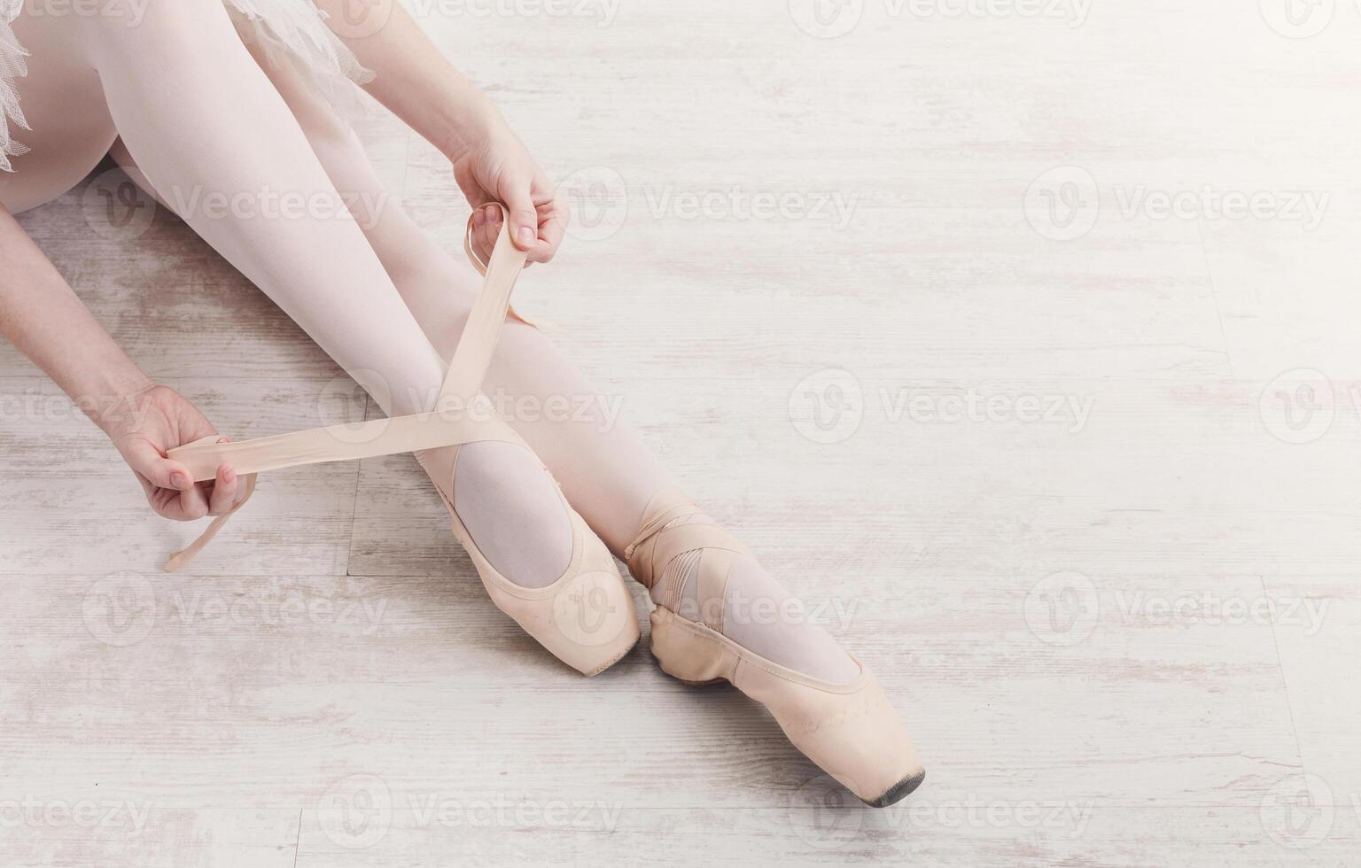 Ballet in pointe background. Beautiful ballerina legs top view on white wood floor photo