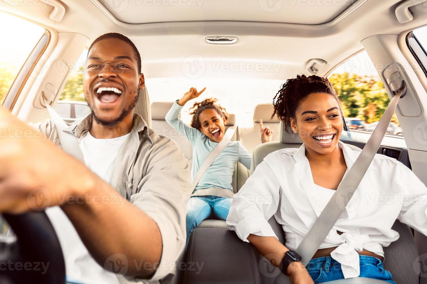 Summer Road Trip. Happy Black Family Of Three Riding Car And Singing Having Fun Traveling By Automobile. Parents And Daughter Enjoying Auto Ride Together On Weekend. Panorama, Selective Focus photo