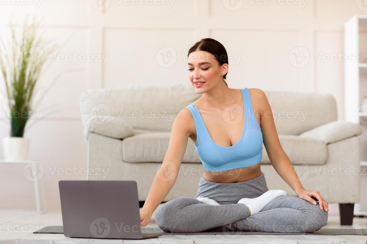 Online Yoga Class. Girl At Laptop Preparing For Meditation Sitting On Rolling Mat At Home. photo