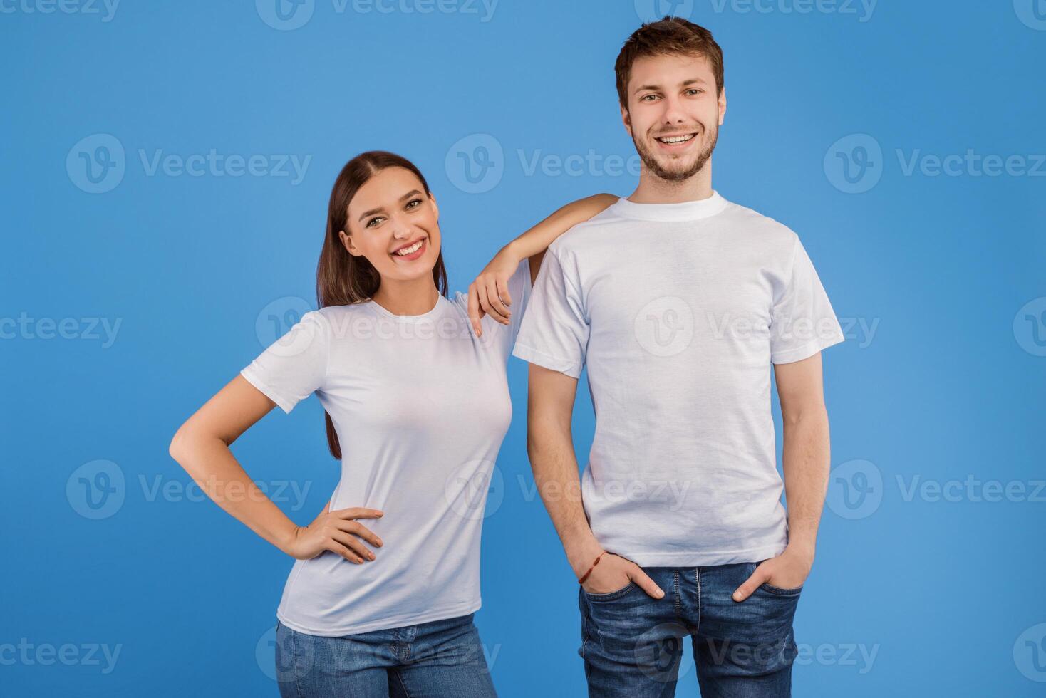 Studio shot of cheerful partners posing at camera, lady leaning hand on her boy friend, isolated on purple wall photo