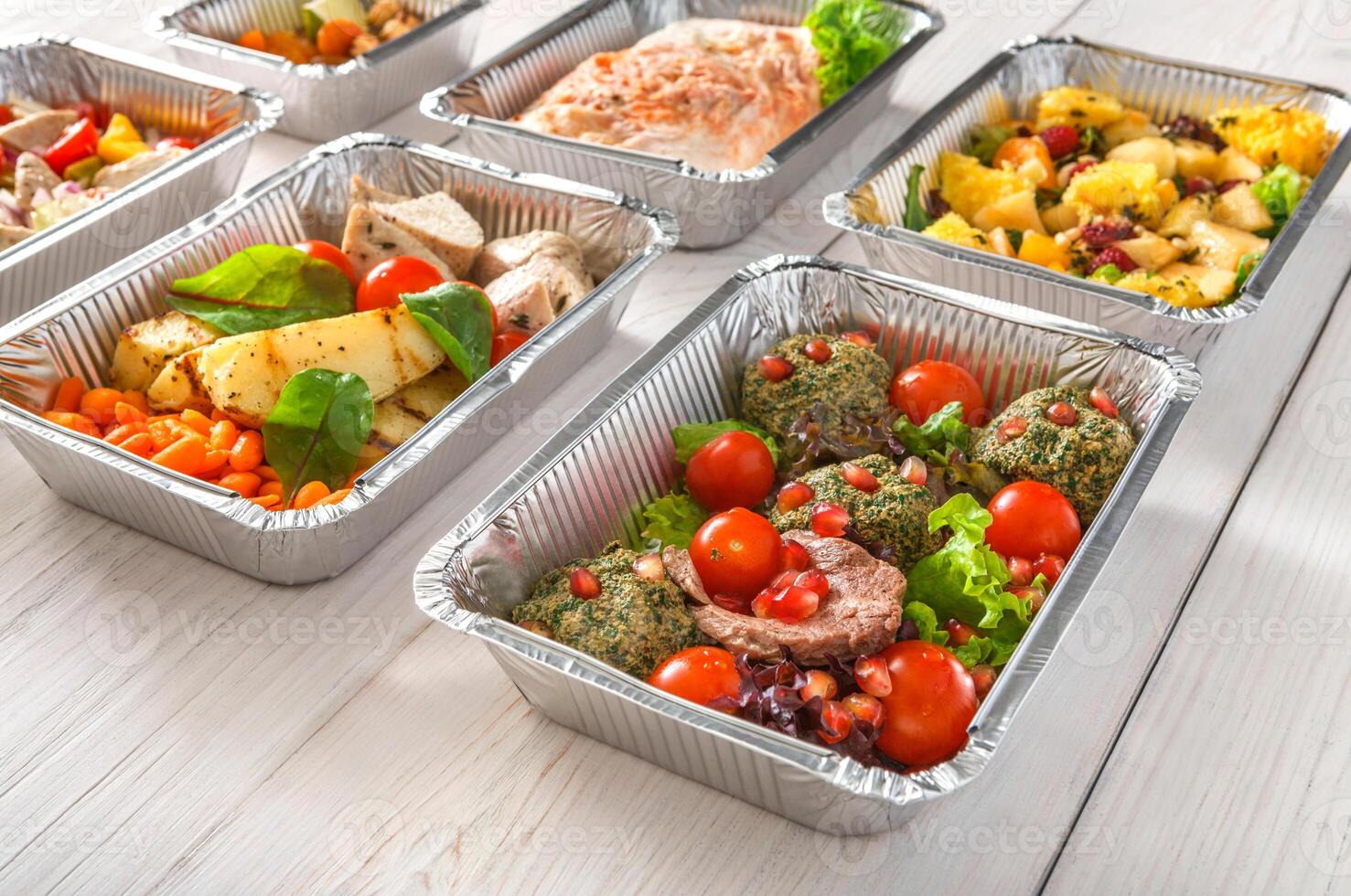 Healthy food background. Take away of natural organic meals in foil boxes. Fitness nutrition, meat, fresh salads, fruits and vegetables. Restaurant dishes delivery photo