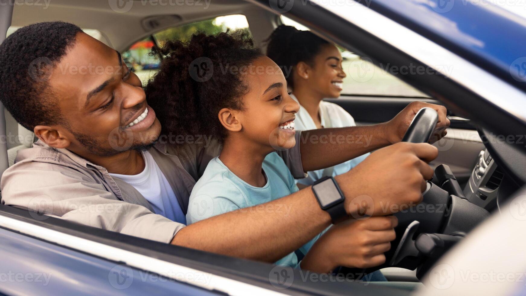 Happy Black Father Teaching Daughter Driving Sitting Together. Kid Girl Learning To Drive Auto Having A Ride With Family In Urban Area. Automobile Ownership Concept. Side View photo