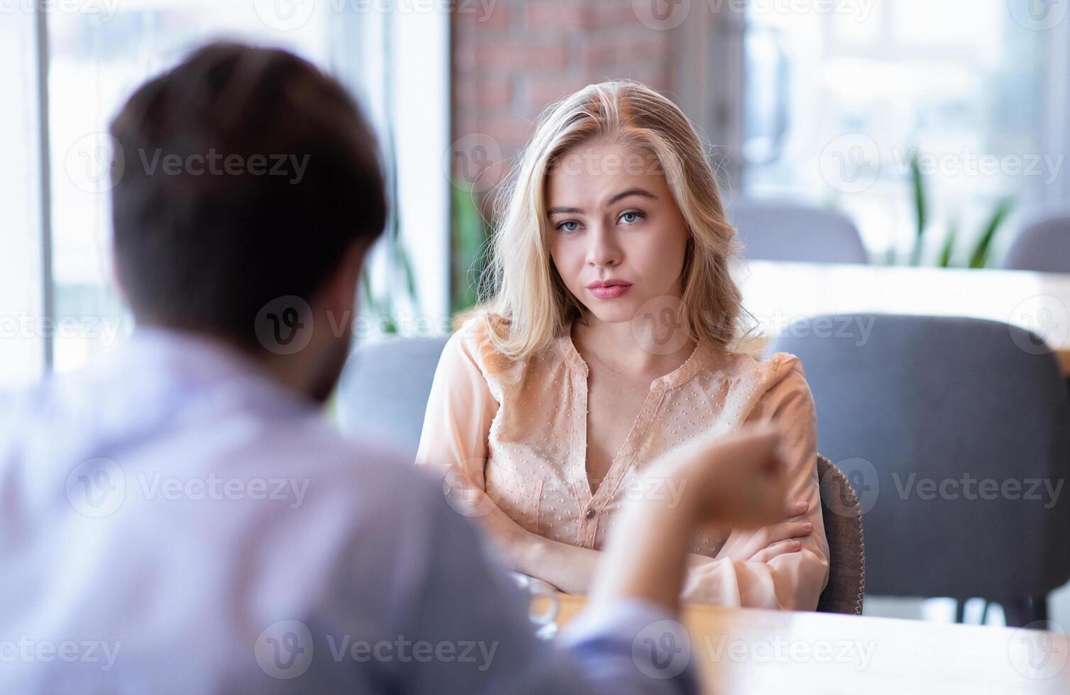 Bad date. Young woman feeling bored during dinner at cafe, unhappy with her boyfriend, disinterested in conversation. Stressed couple having difficulties in relationship, arguing in coffee shop photo