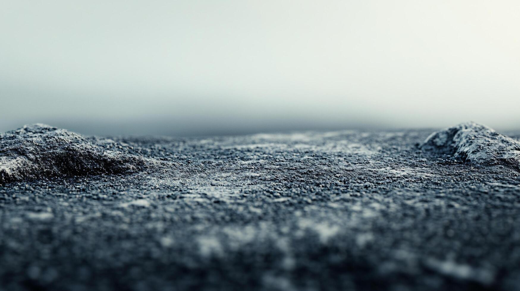 A desolate landscape with a few rocks and a small hill photo
