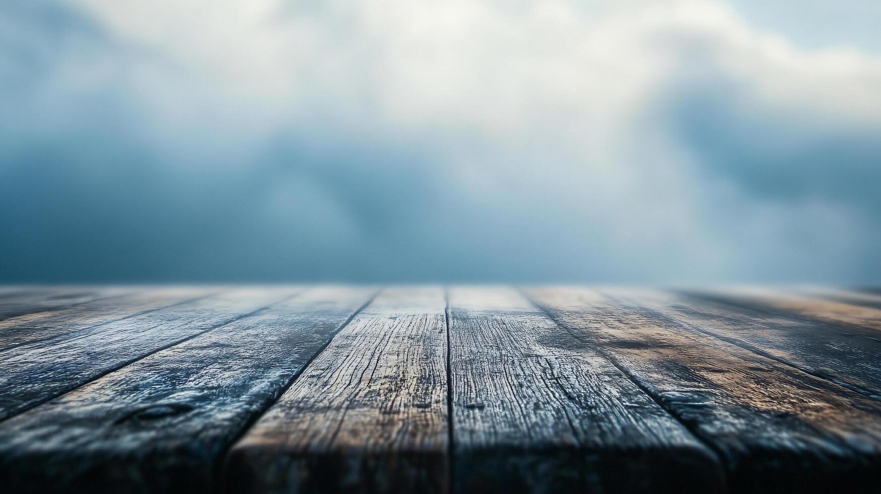 A wooden table with a cloudy sky in the background photo