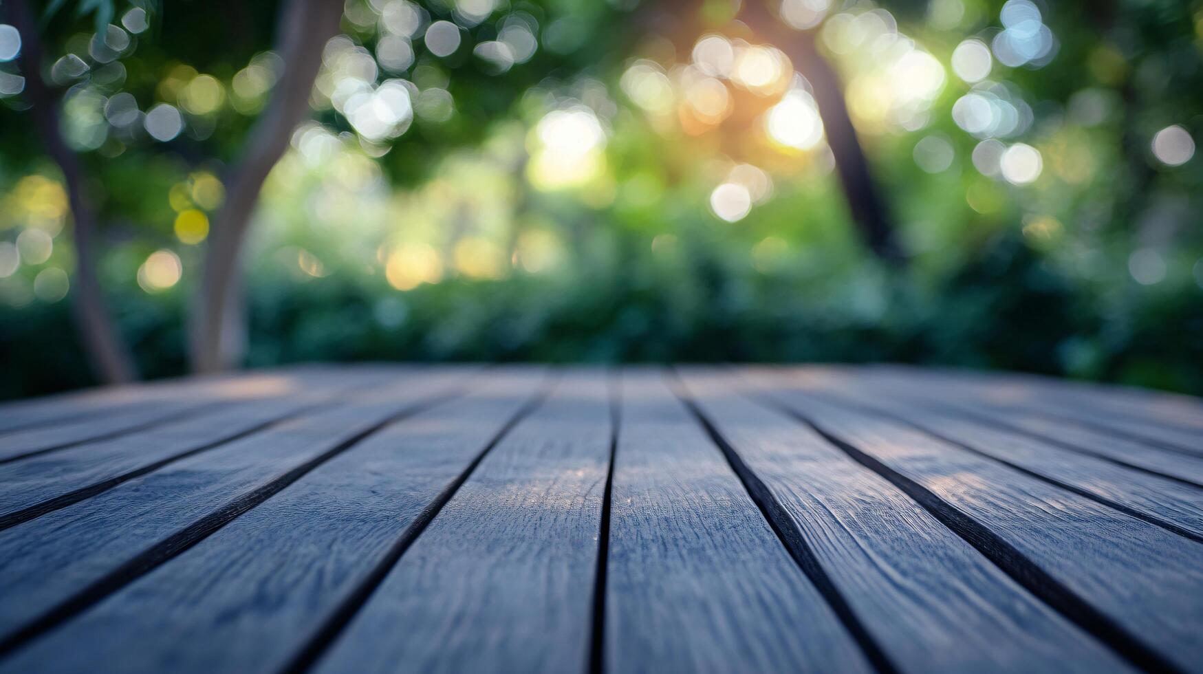 A wooden table with a view of trees and a bright sun photo