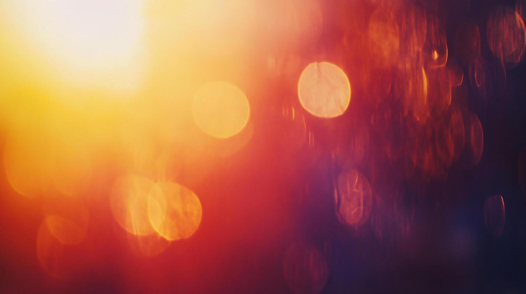 A blurry orange and red background with a sun in the top left corner photo