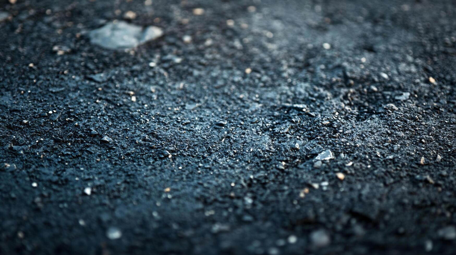 A close up of a black and gray surface with a few small rocks photo
