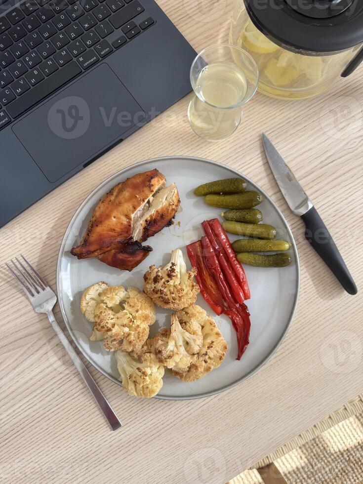 Delicious home-cooked meal featuring salmon and vegetables on a wooden table photo