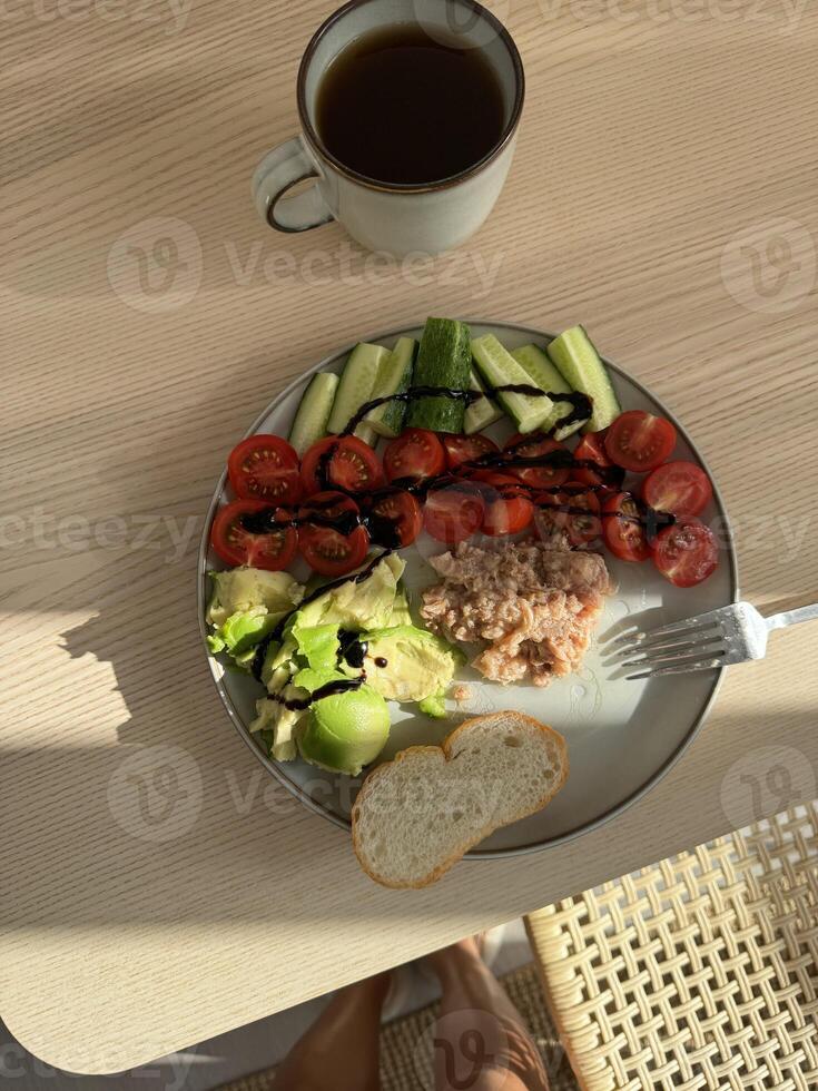 Healthy breakfast with fresh vegetables and bread served on a wooden table photo